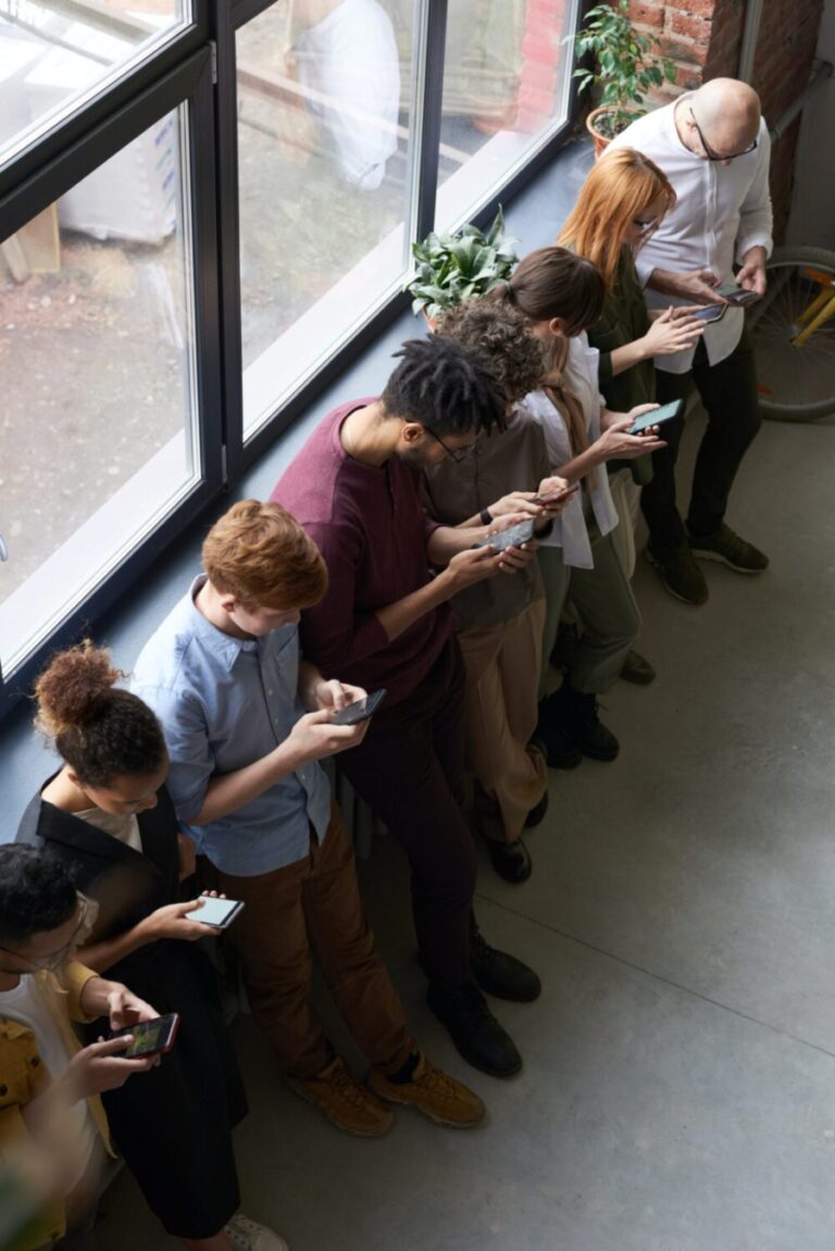 people in a line scrolling on their phone