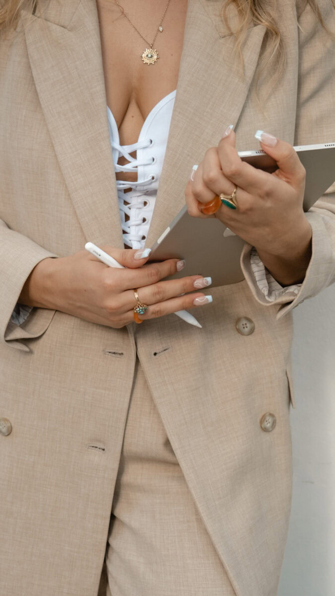 a woman wearing a suit and holding a tablet