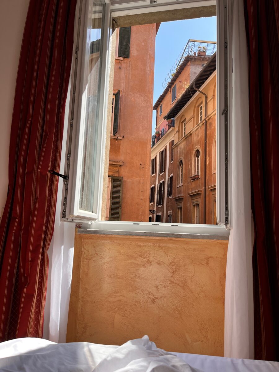 a window overlooking the coloured walls of the city of Rome