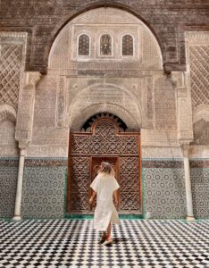 a woman twirling in a beautiful Moroccan architecture, Al Attarine Madrasa