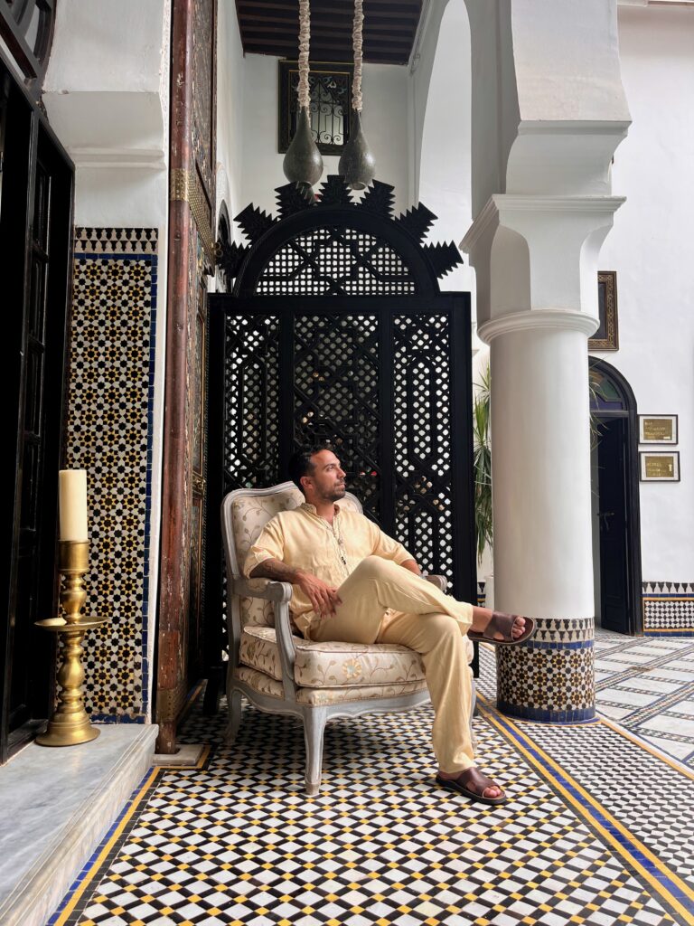a man seating in a chair in a riad of Fez, Morocco