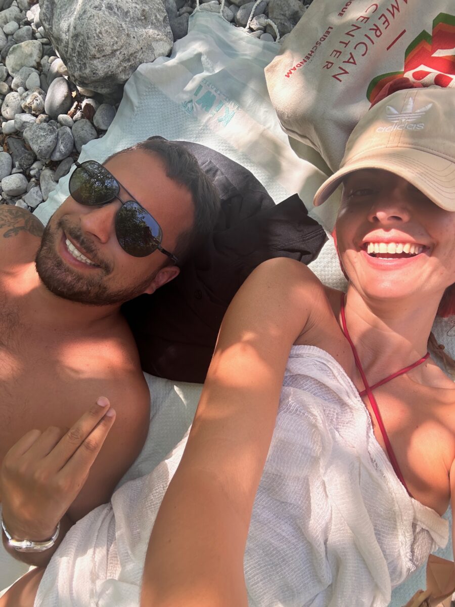 two people laughing while sunbathing