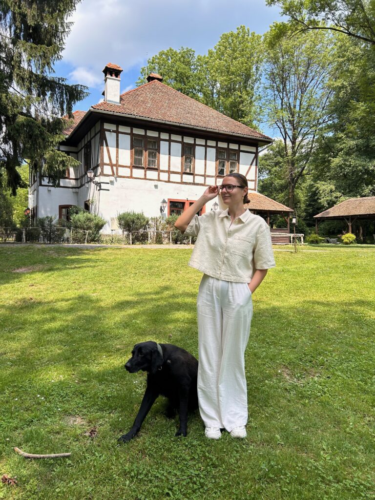 A woman and a dog in front of the Machine House at Zabola Estate in Romania