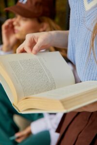 the hands of a woman holding a book open