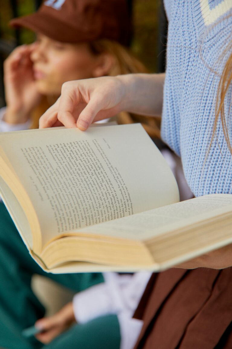 the hands of a woman holding a book open