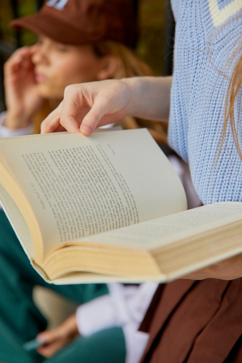 the hands of a woman holding a book open