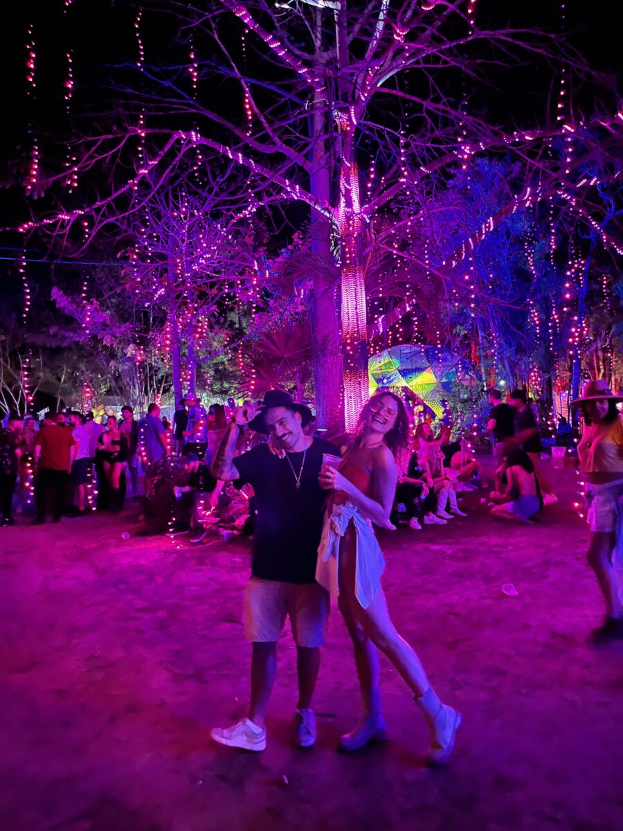two people posing at night in front of a light art installation in the jungle of Tulum
