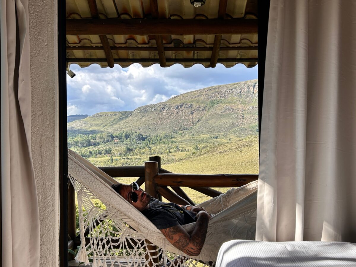 a man in a hammock with a view over the mountains of Serra do Cipo